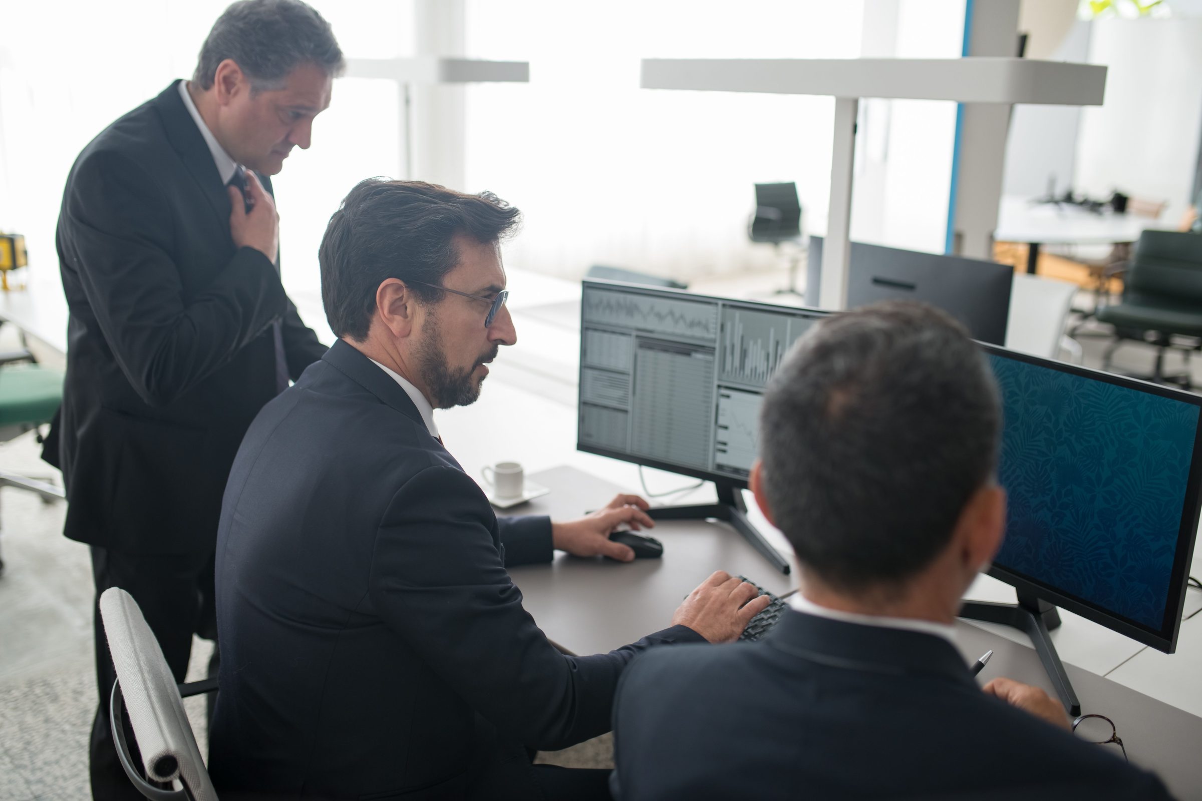 Team reviewing automated work across multiple screens in a bright office