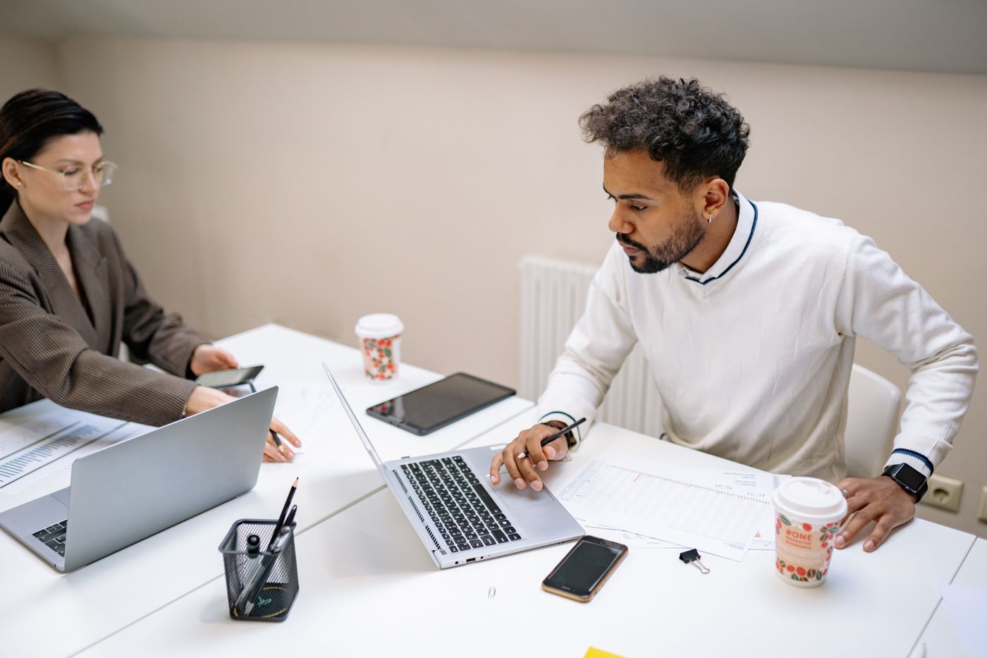 Colleagues working together at laptops in a bright office
