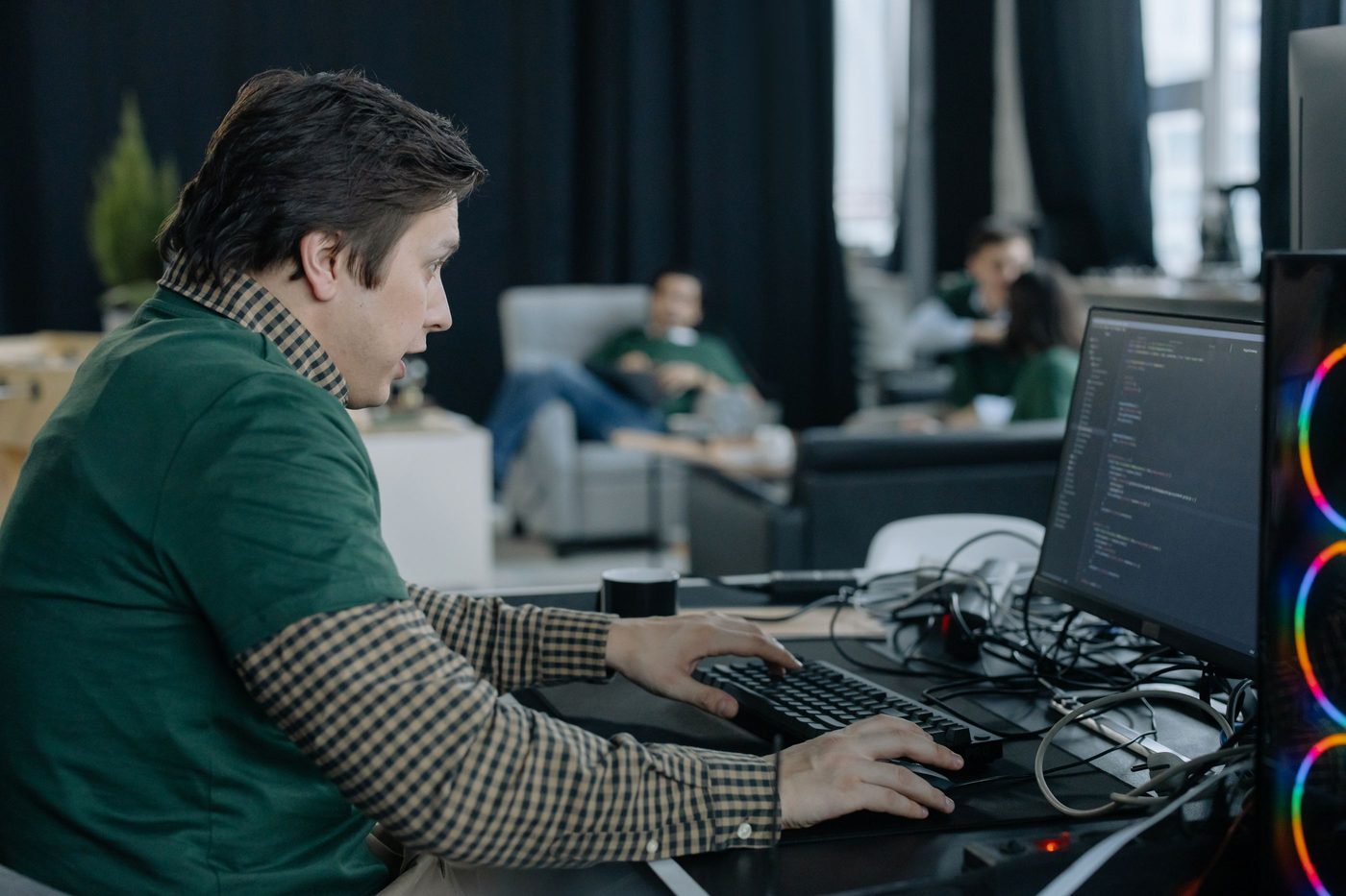 Developer typing at a workstation with code on the monitor