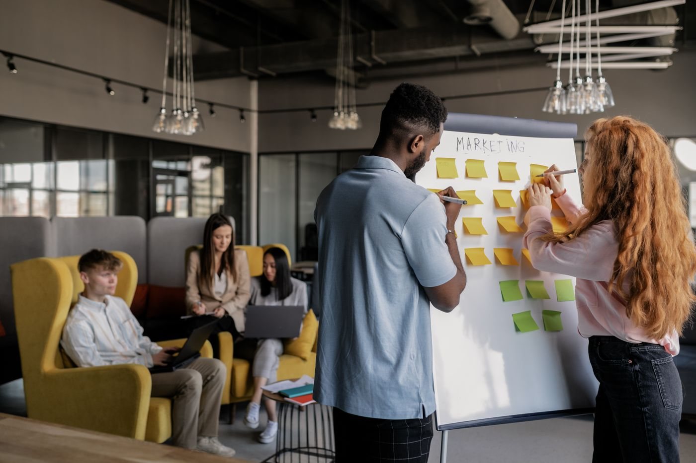 Colleagues organizing go-to-market tasks on a sticky-note board
