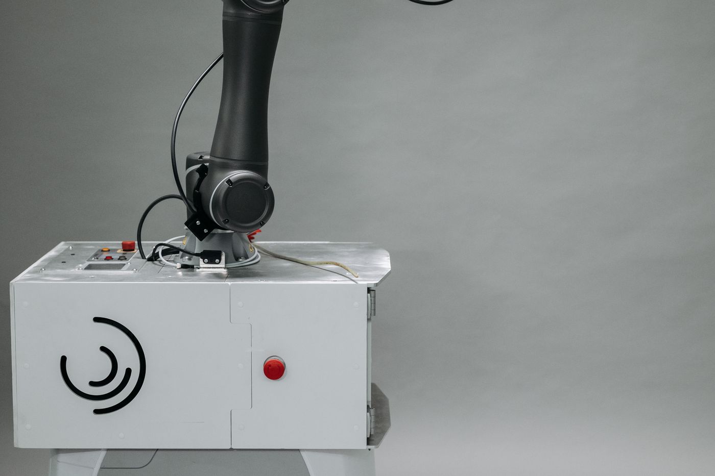 Close-up of a robotic arm mounted on an industrial control unit