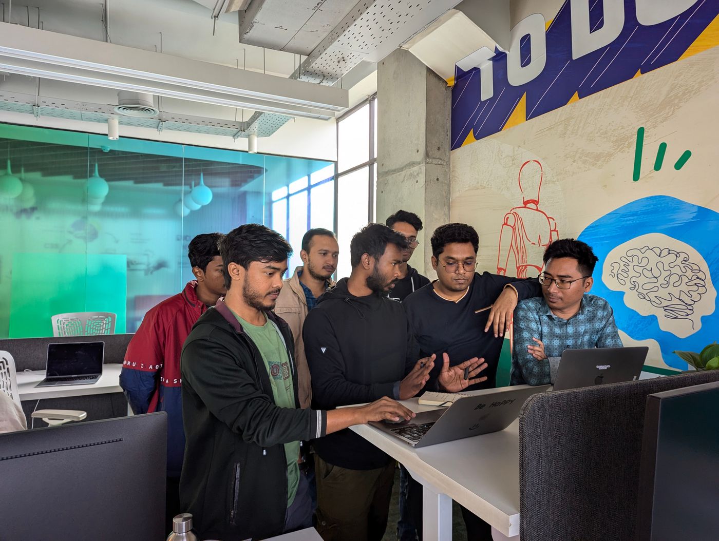 Engineering team gathered around a laptop in a startup office