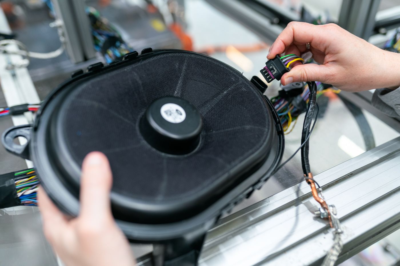 Technician wiring an automotive component on an assembly line