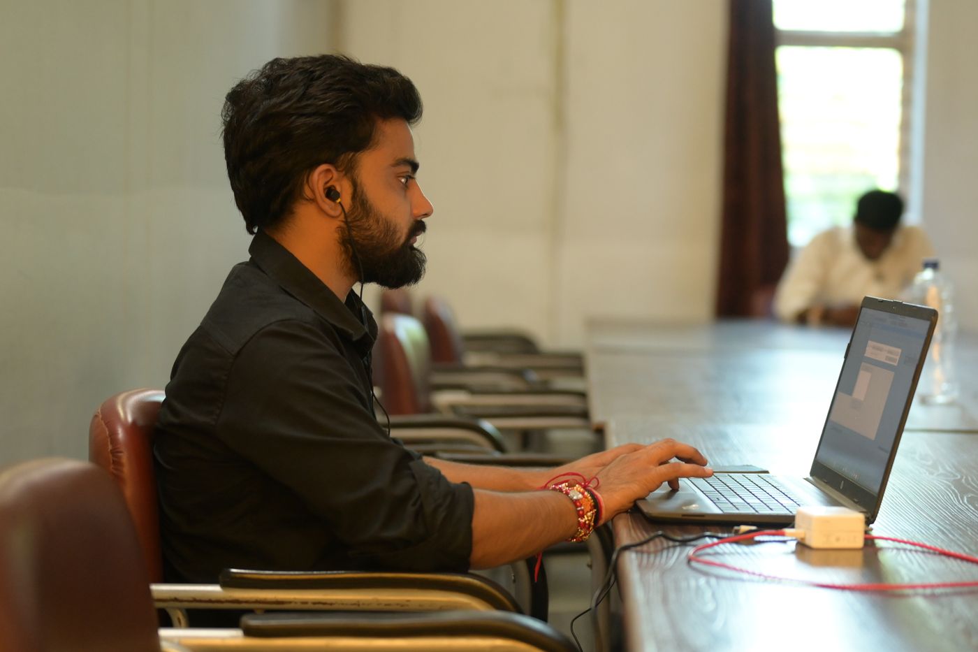 Professional working on a laptop at a boardroom table