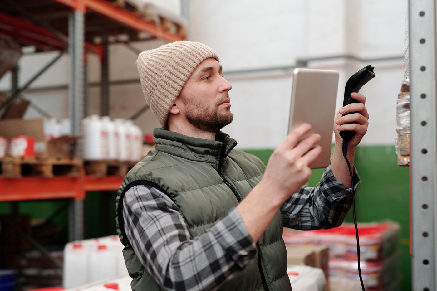 Warehouse worker checking stock with a tablet and scanner