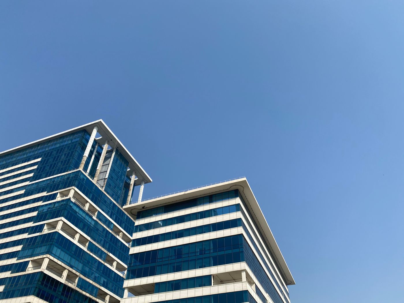 Modern glass office building against a blue sky