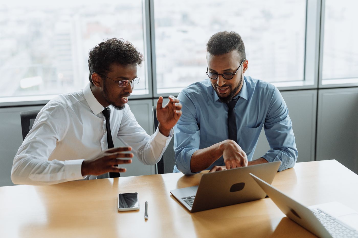 Two colleagues working through a solution at a laptop