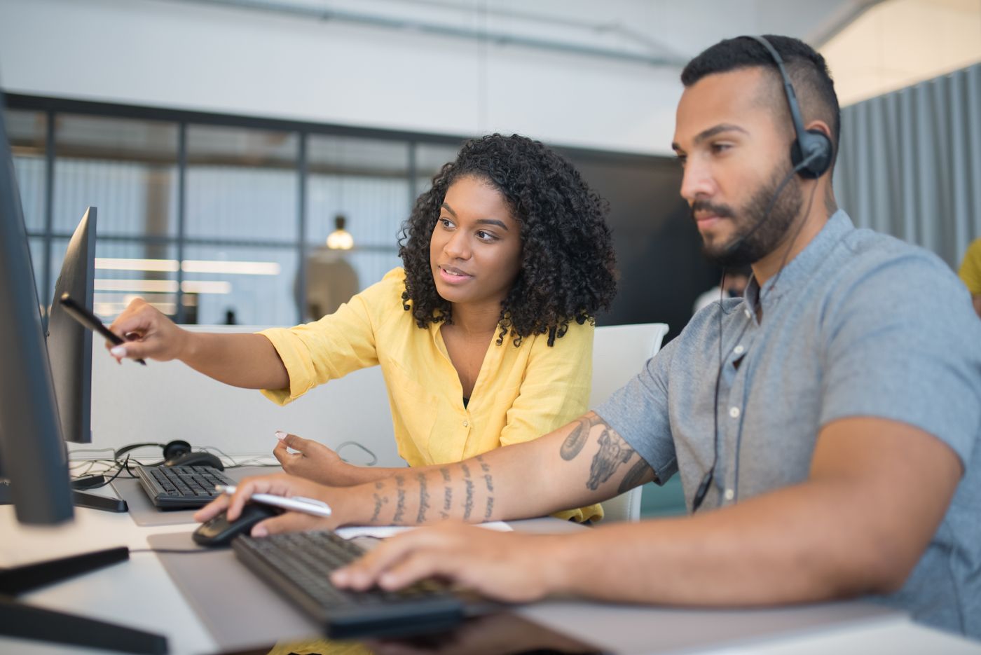 Two revenue operations colleagues aligning systems at a monitor