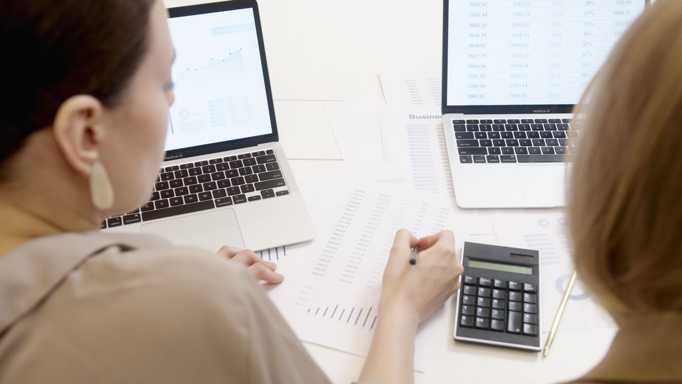 Analyst modeling CRM data beside a laptop