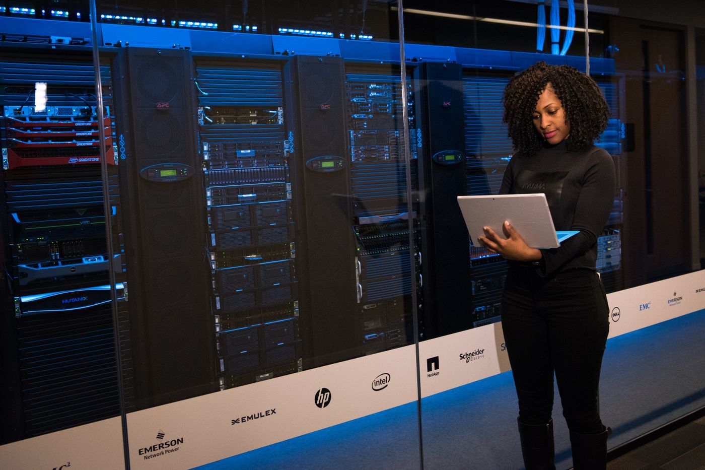 Engineer with a laptop beside data centre server racks
