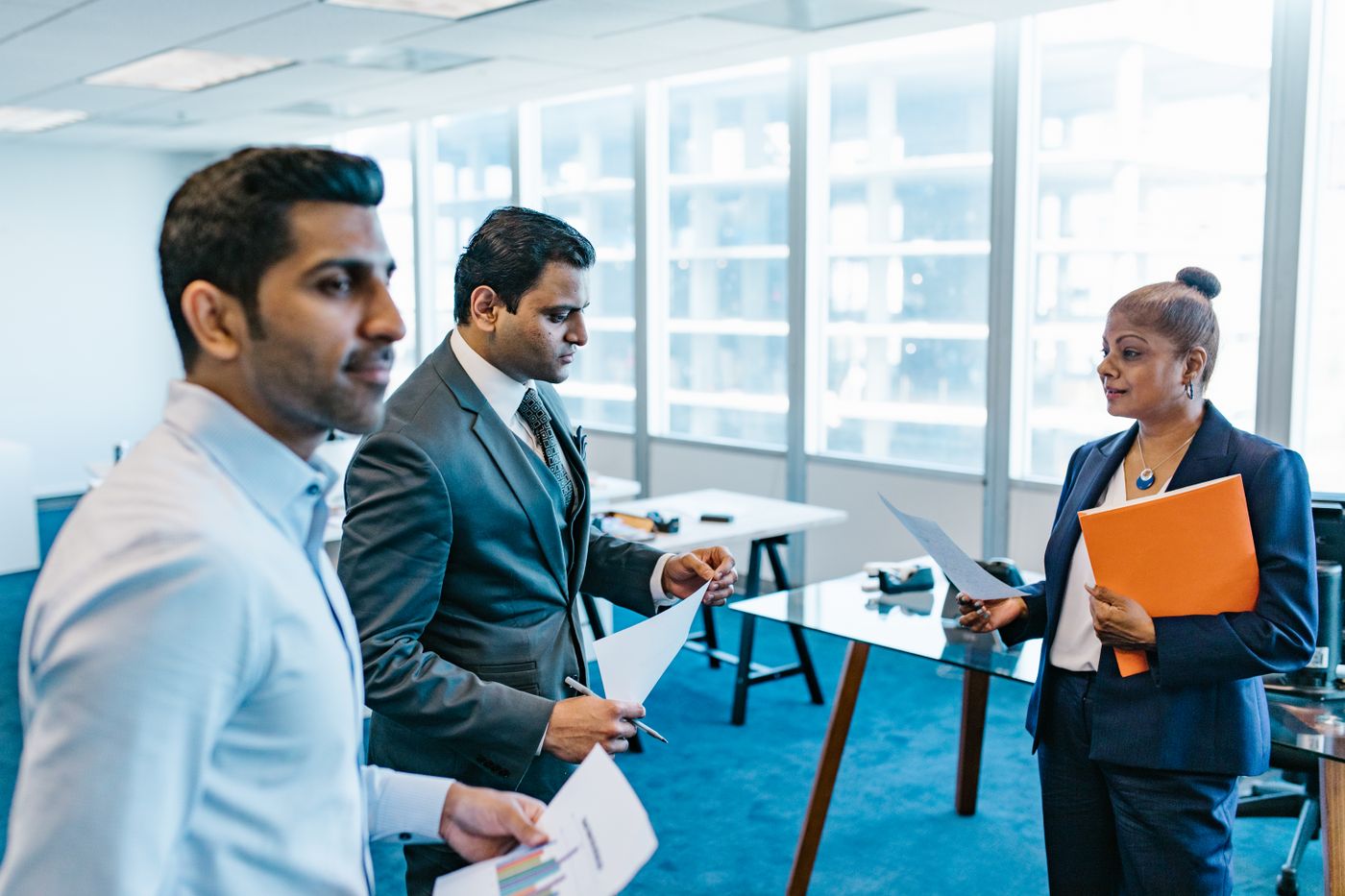 Colleagues handing off account documents in the office