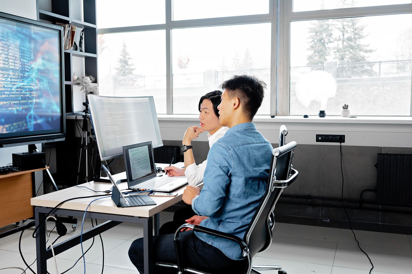 Engineers working at desks with large monitors in a modern office