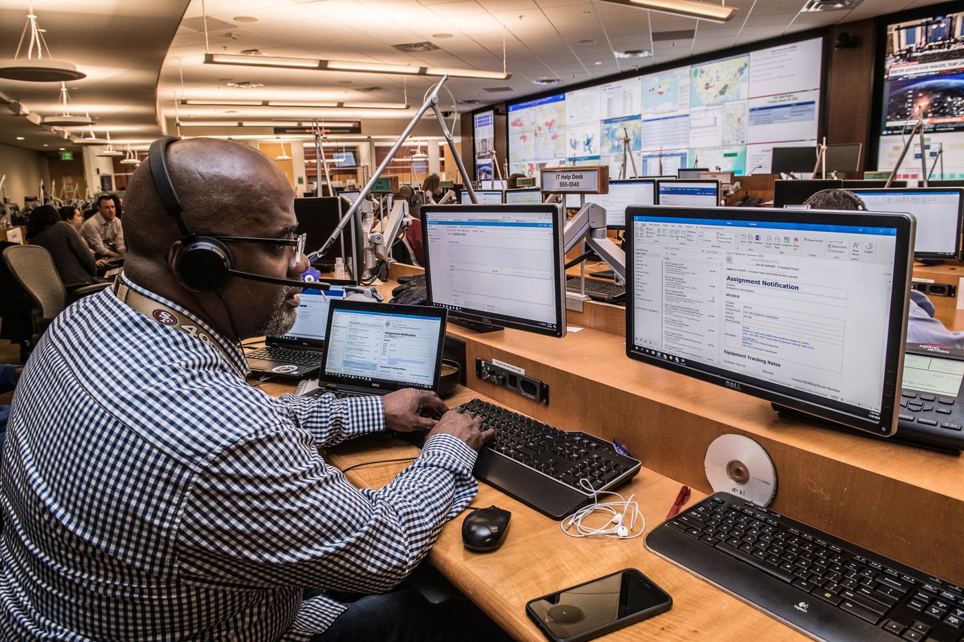 Operator working across several monitors in an operations centre