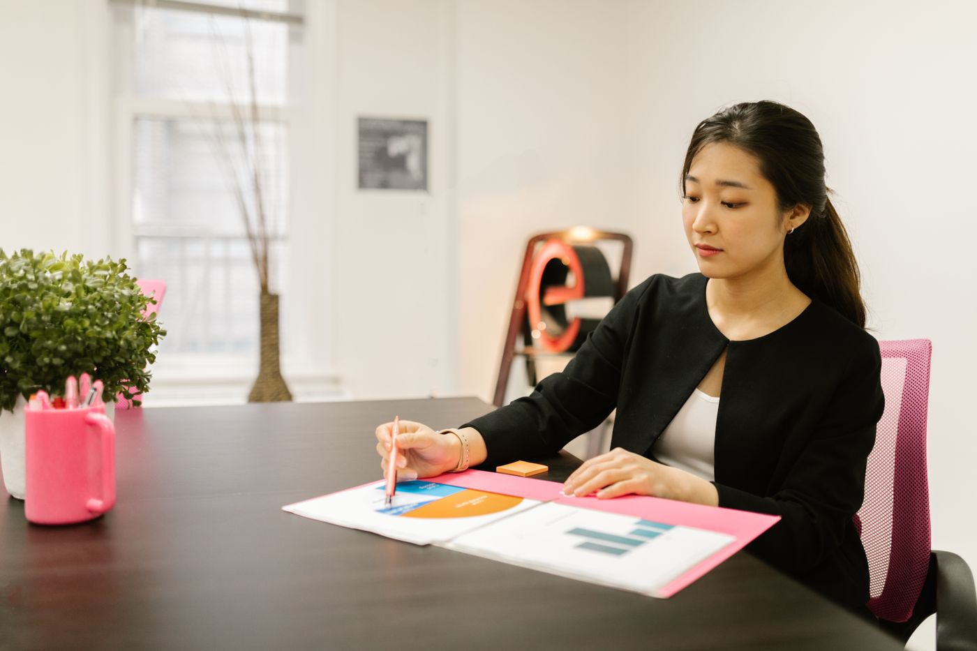 Professional reviewing printed reports and charts at an office desk