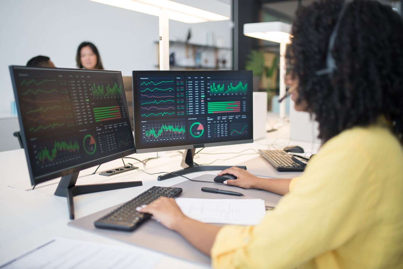 Analyst working through revenue data on two screens