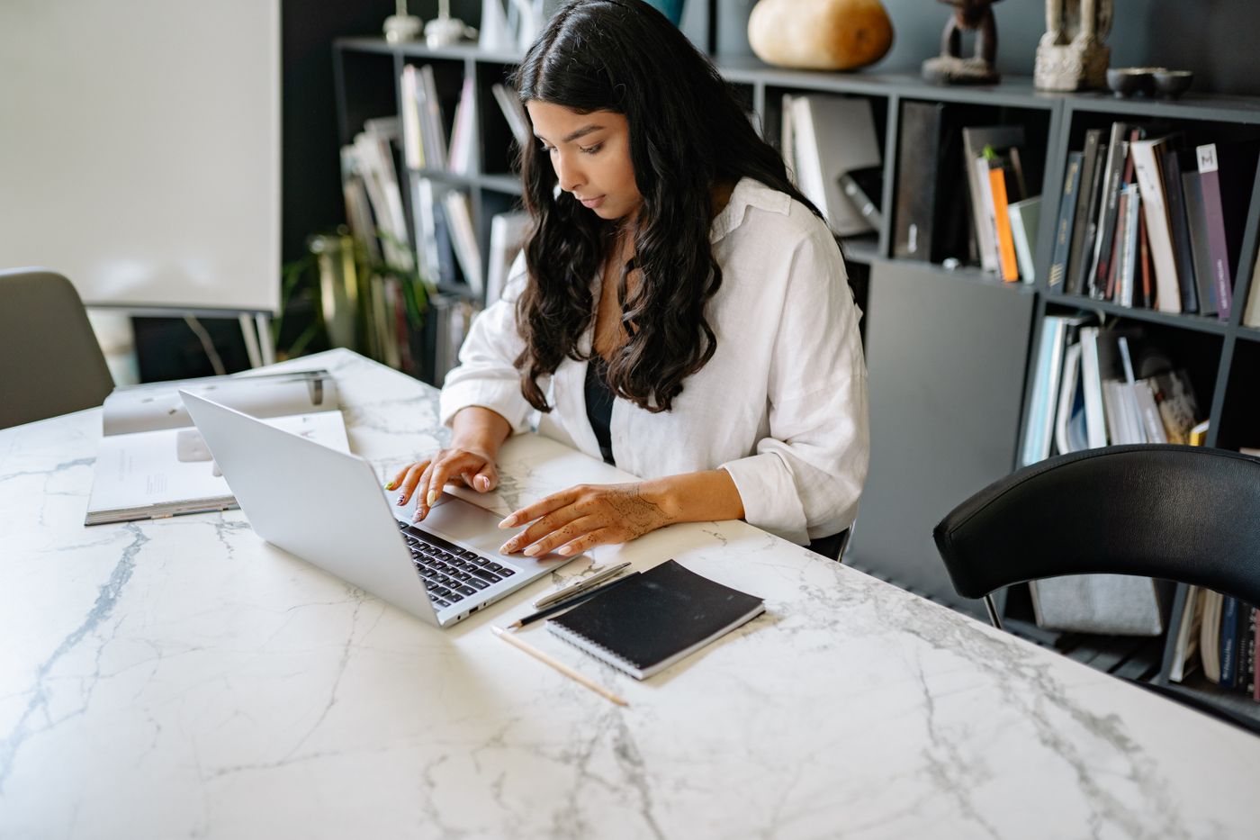 Analyst building a revenue report on her laptop