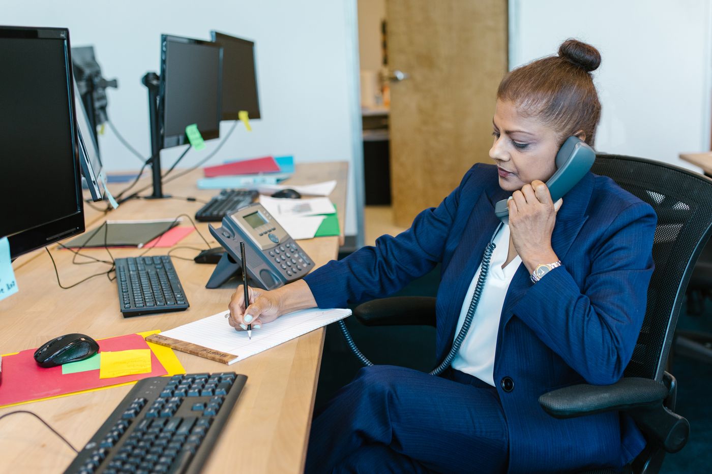 Sales rep prospecting by phone at her desk