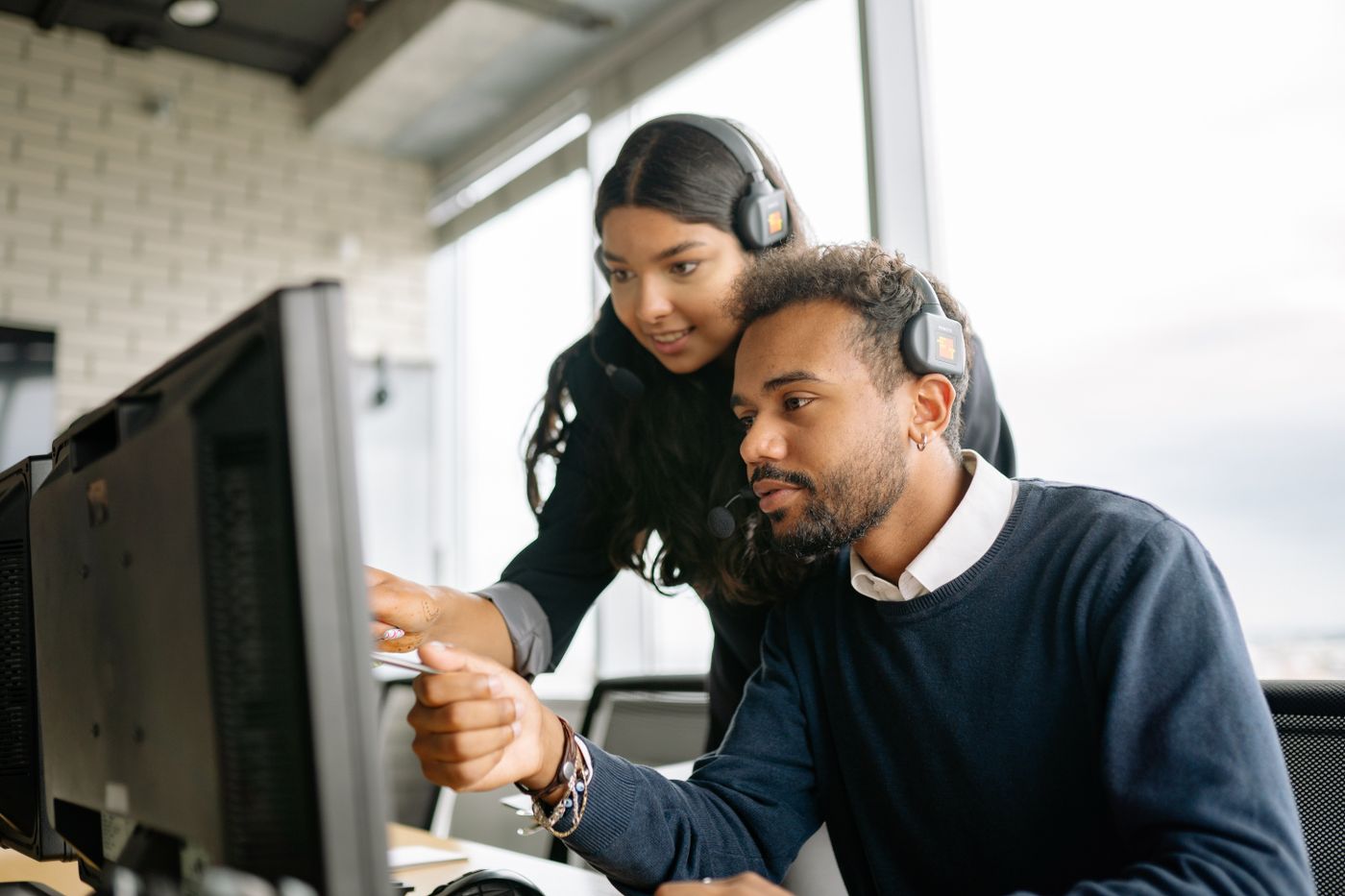 Two colleagues building a workflow at a computer