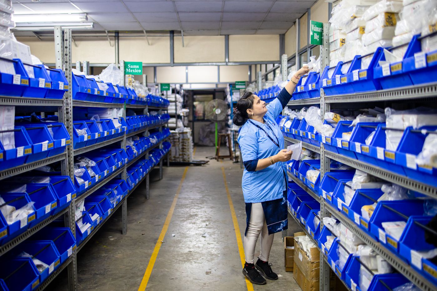 Pharmacy worker checking stock on warehouse shelves